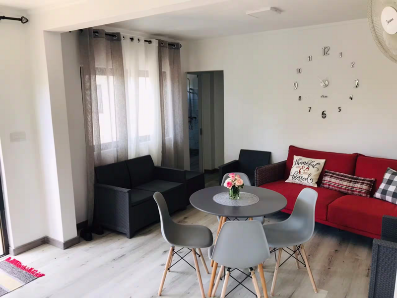 Living and dining area with black and red sofas beside the patio doors